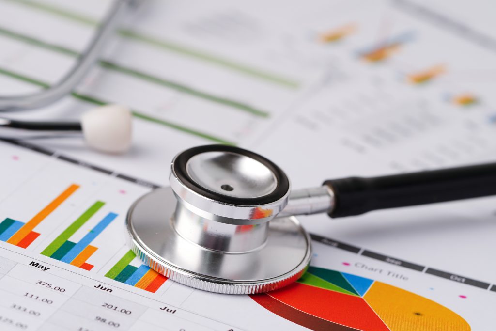 Image of stethoscope sitting on top of papers showing graphs and charts