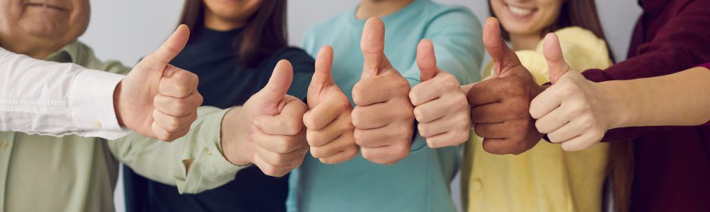 Image of seven people giving thumbs-up together.