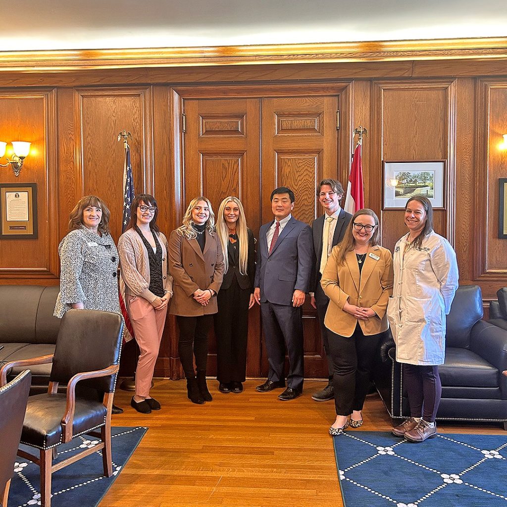 Four Mizzou medical students posing with representatives from the MRHA, Missouri AHEC, and Speaker of the House, Dr. Jon Patterson.